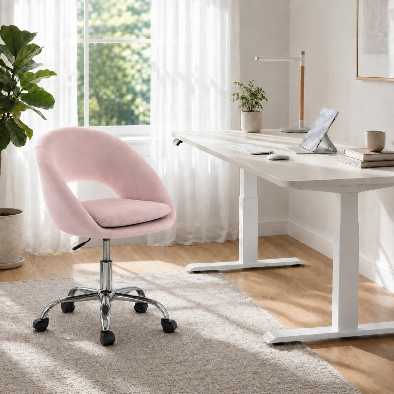 Pink velvet swivel desk chair with rounded back, cushioned seat, and caster wheels