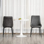 Pair of grey quilted PU leather side chairs with black metal legs and cushioned backs