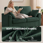 Dark green corduroy 2-seat sofa with two pillows, person lounging and reading