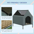 Grey elevated dog house with arched door and top mesh windows; water-resistant pad shown.