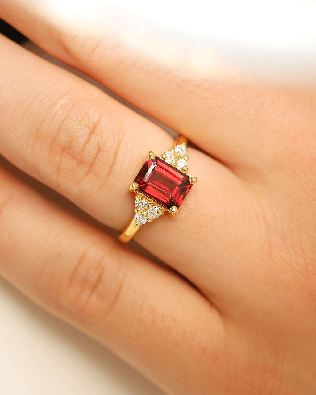 Gold vermeil ring with red emerald-cut stone and tiny round clear side stones