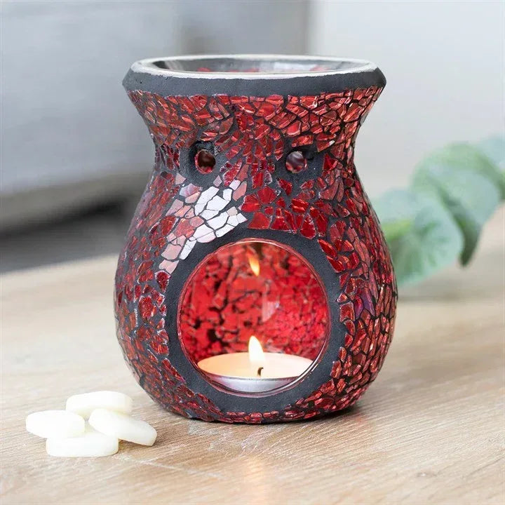 Red crackle glass oil burner with flame-lit candle in circular opening