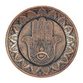 Round incense holder plate with hand of Hamsa design, circular patterned rim, bronze tone