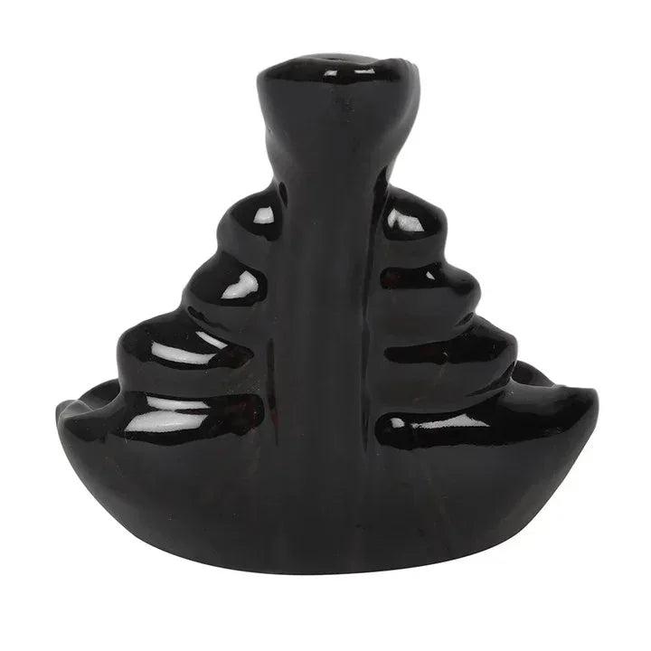 Black glossy incense backflow burner shaped like a seated figure with tiered base
