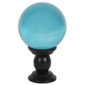 Large teal crystal ball on black pedestal stand