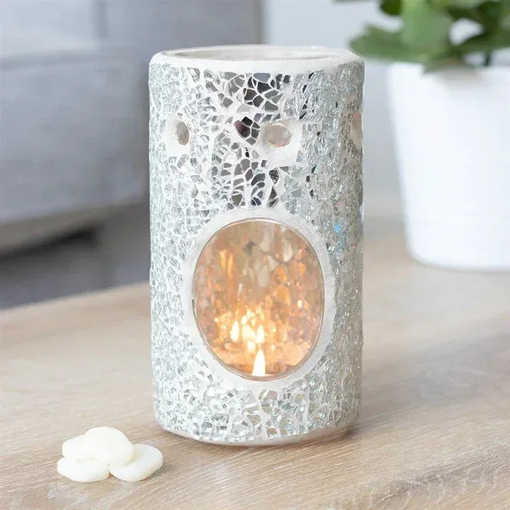 Crackle glass oil burner with glowing flame behind round window, silver cylinder