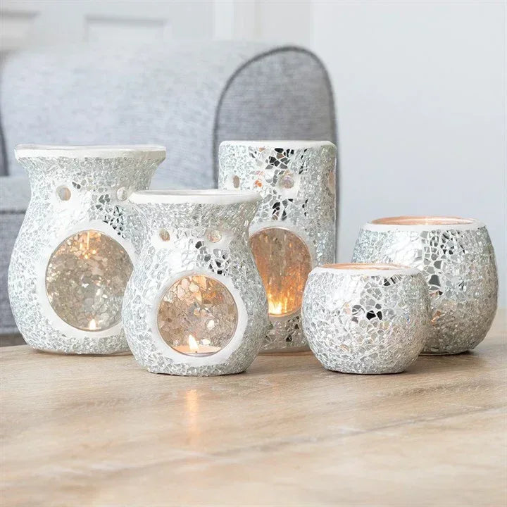 Silver crackle wax warmer oil burners in multiple sizes with lit flames on table