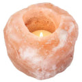 Pink salt candle holder with round bowl and lit tealight inside