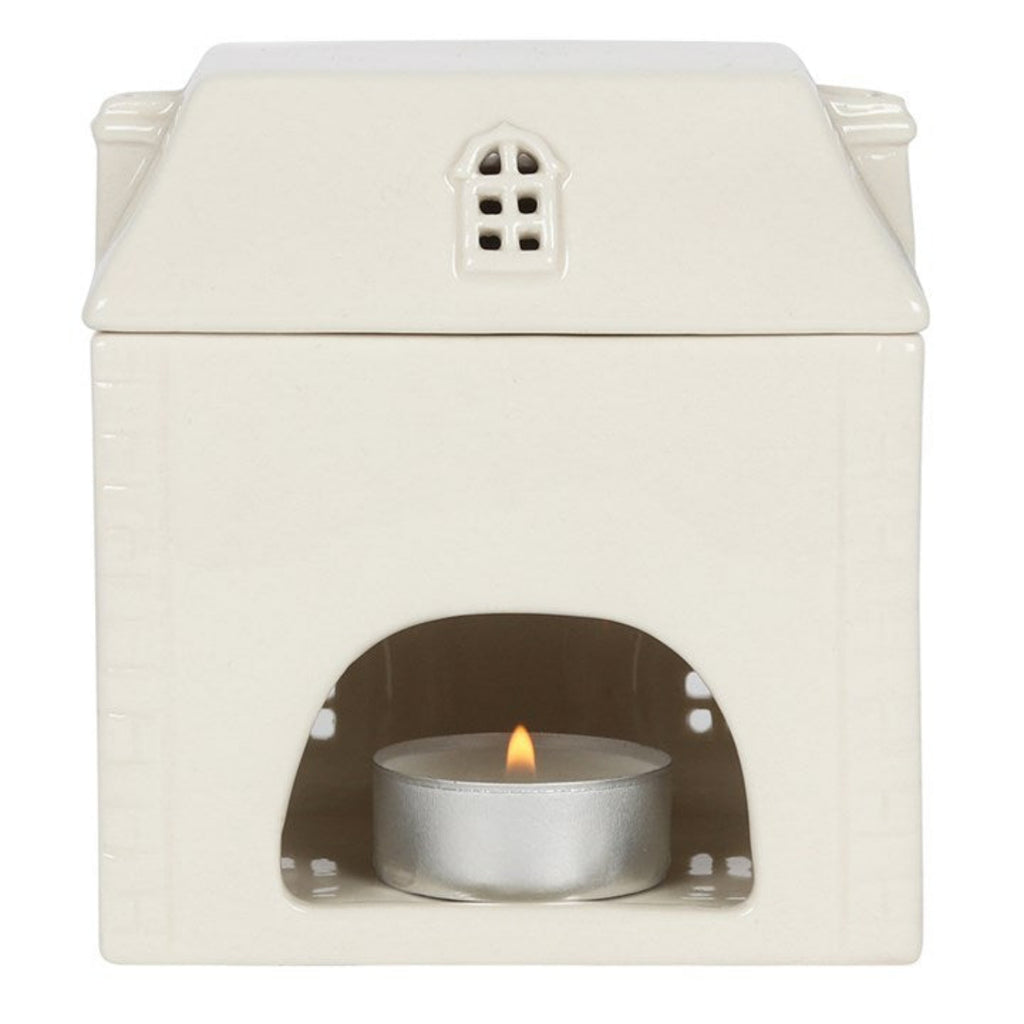 White ceramic oil burner with a small candle inside on a white background