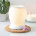 White ceramic electric oil burner with embossed elephant, cork base and glowing light