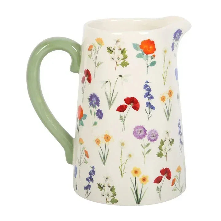 Ceramic flower jug with cream body, green handle, and colorful wildflower print