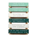 Wooden block gardening signs stacked, with phrases like 'Welcome to My Garden'