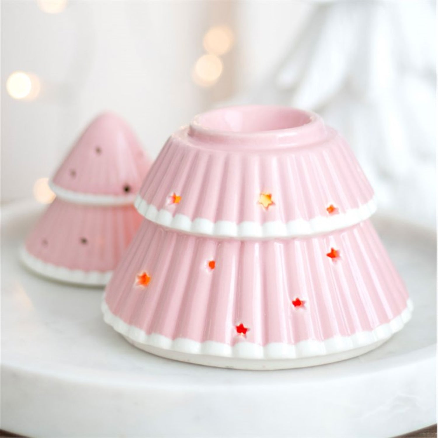 Two pink ceramic cake stands with decorative stars on a white surface.