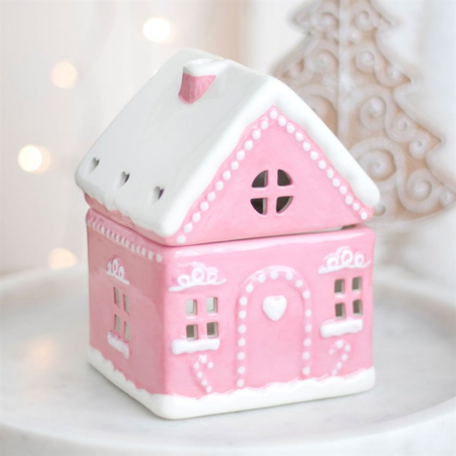 Pink house-shaped container with white roof on a light background
