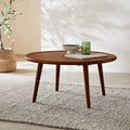 Wooden coffee table with decorative items in a room with a plant and rug.