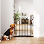 Black dog gate in a doorway with vertical bars and pressure-mounted brackets