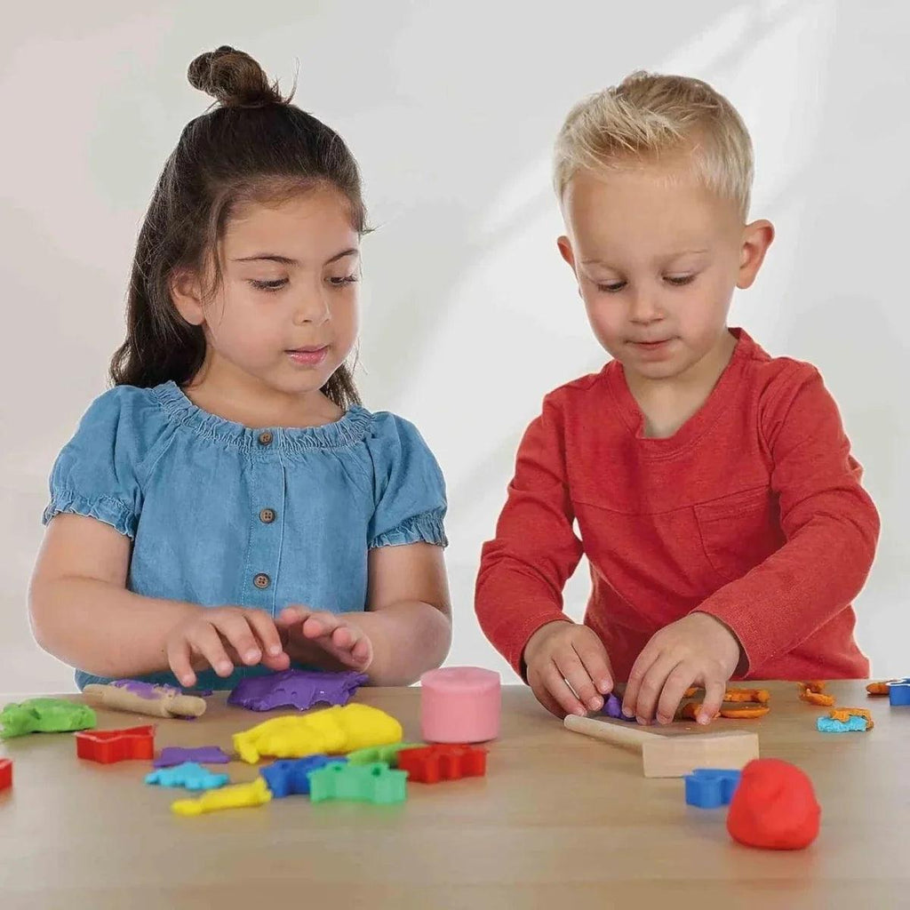 Colorful glow dough shapes on table, kids using molds and pieces