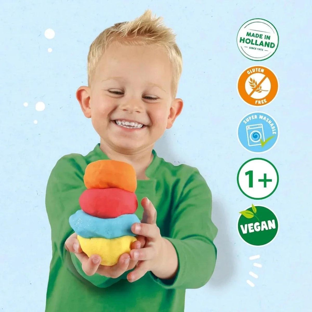Child holding stack of colorful glow dough balls, green shirt, smiling