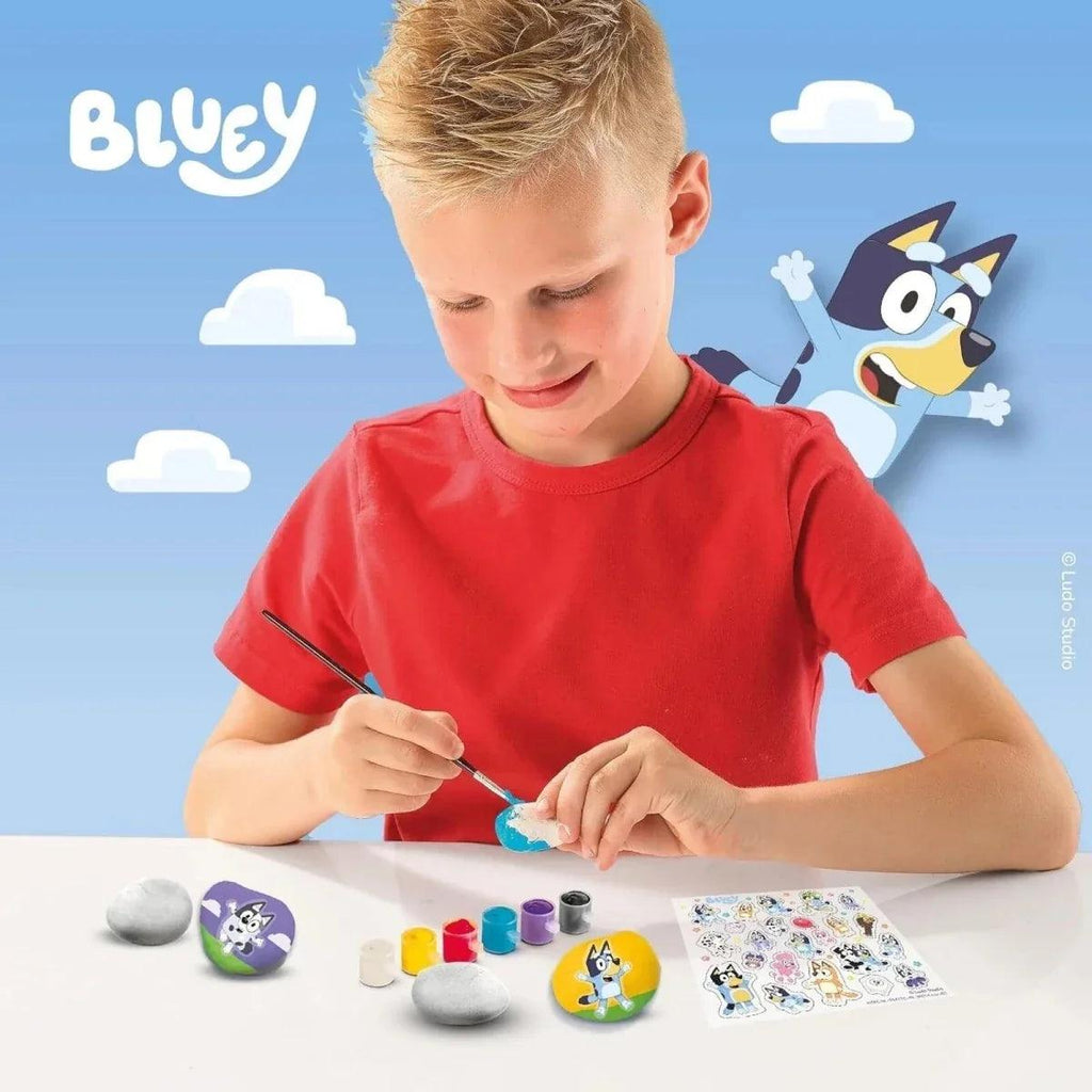Kids rock painting kit with painted stones, paint pots, brush, and sticker sheet