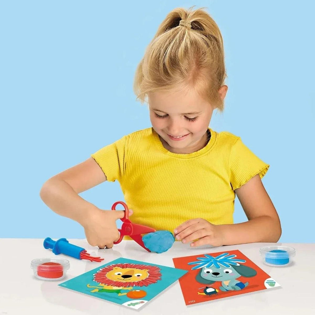 Child using dough hairdresser kit with tools and animal art cards on table