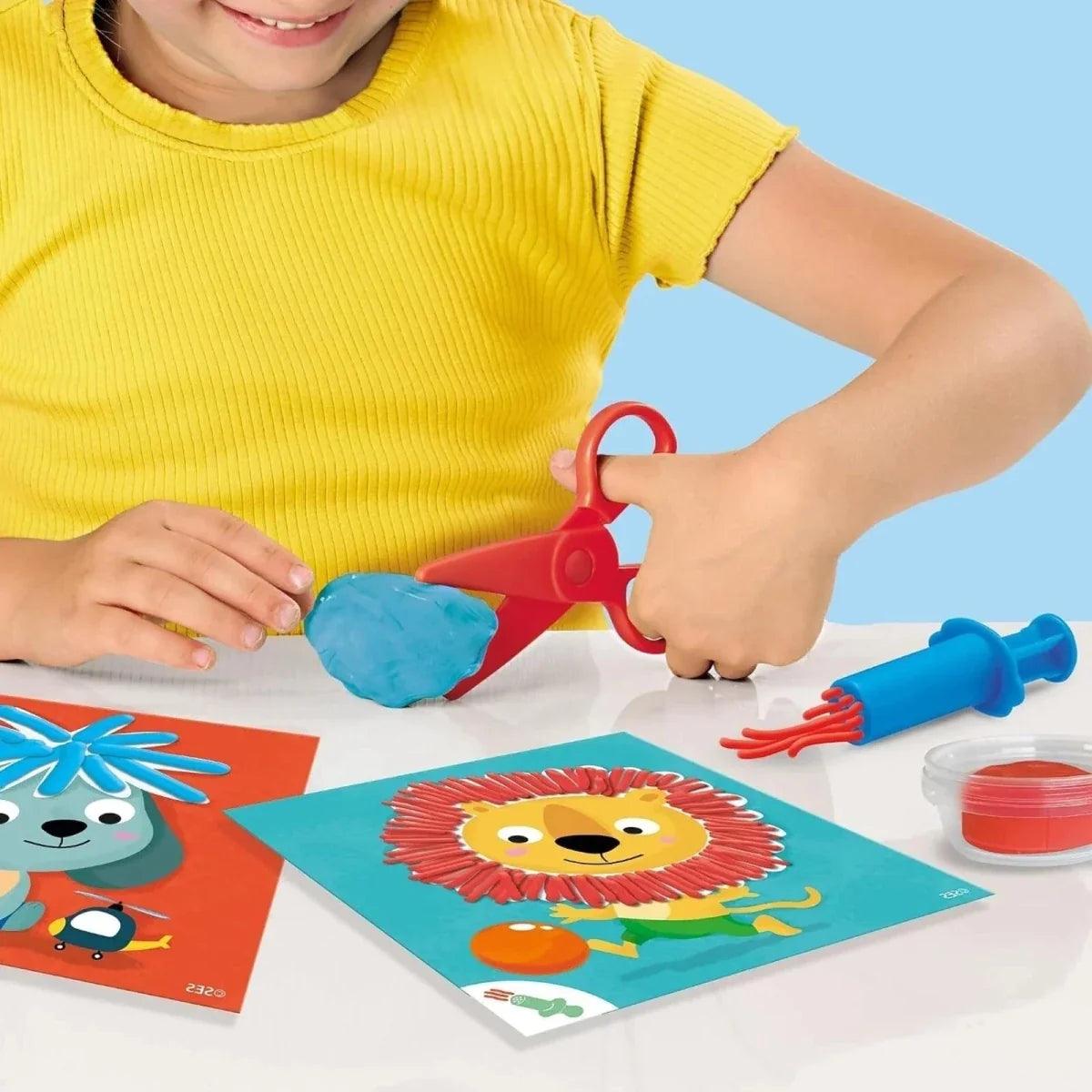 Hands molding blue dough with hairdresser tool over animal art cards