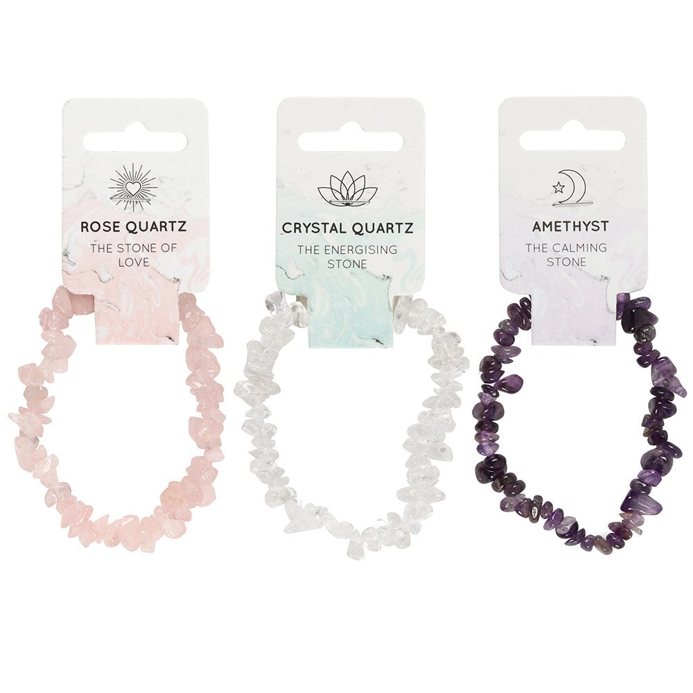 Three crystal hair ties on their packaging with descriptions of stones and stones' energies.