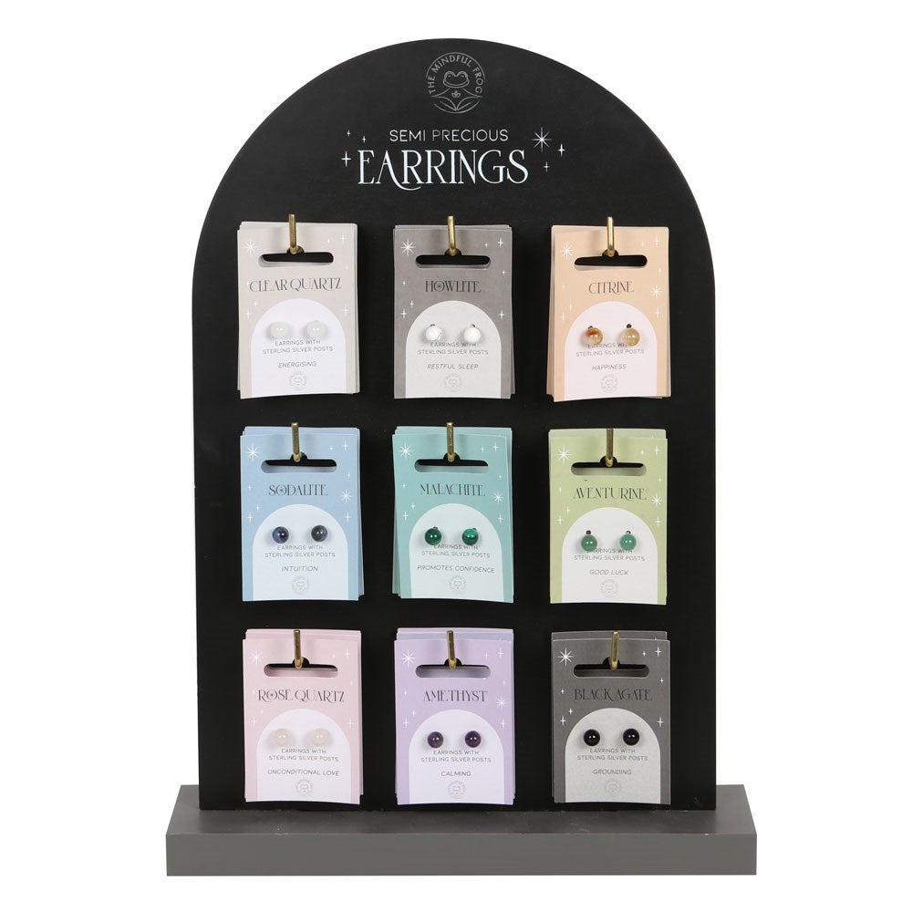 Display of semi-precious earrings with name tags on a black stand.