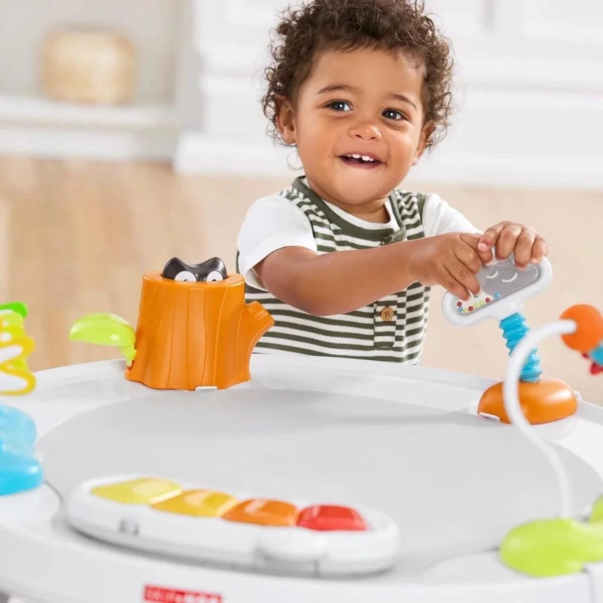 Baby reaching for toy pieces on the activity tray of the baby activity centre