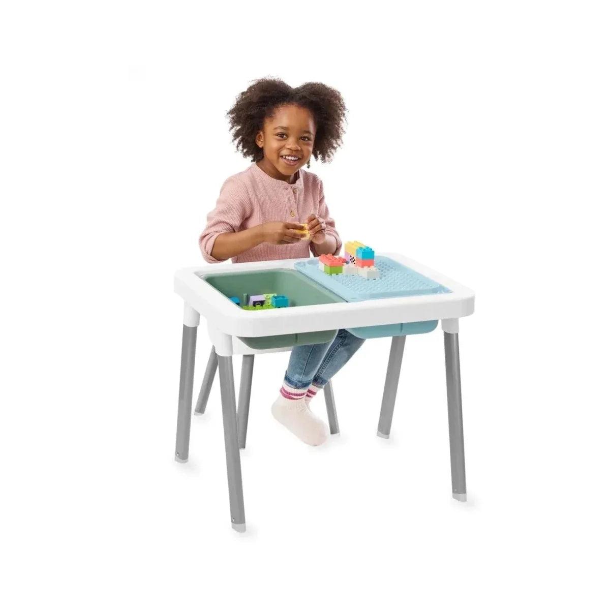 Children playing at white sensory table with blue-green bin and toys