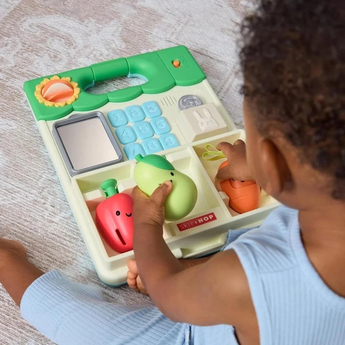 Child hands playing with green front activity panel featuring keypad and spinner