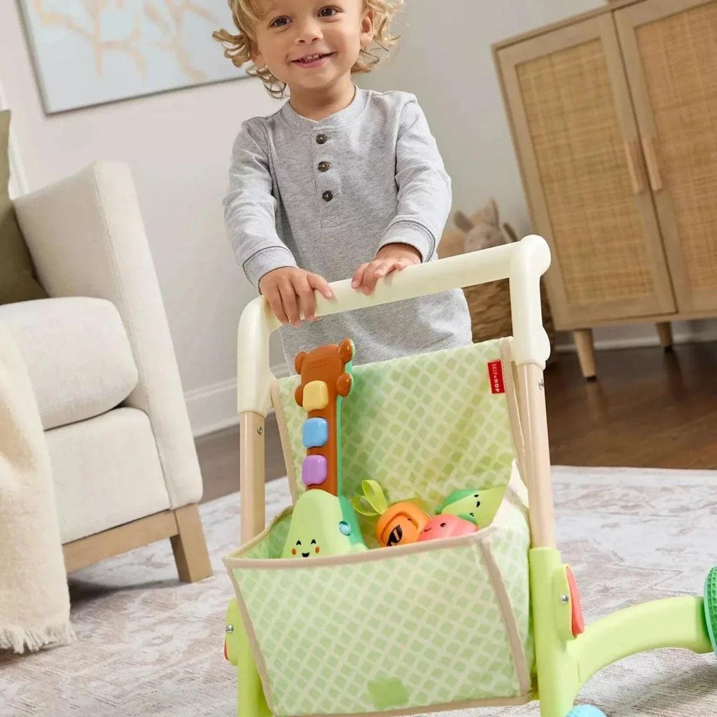Green ride-on walker with front basket holding soft toys