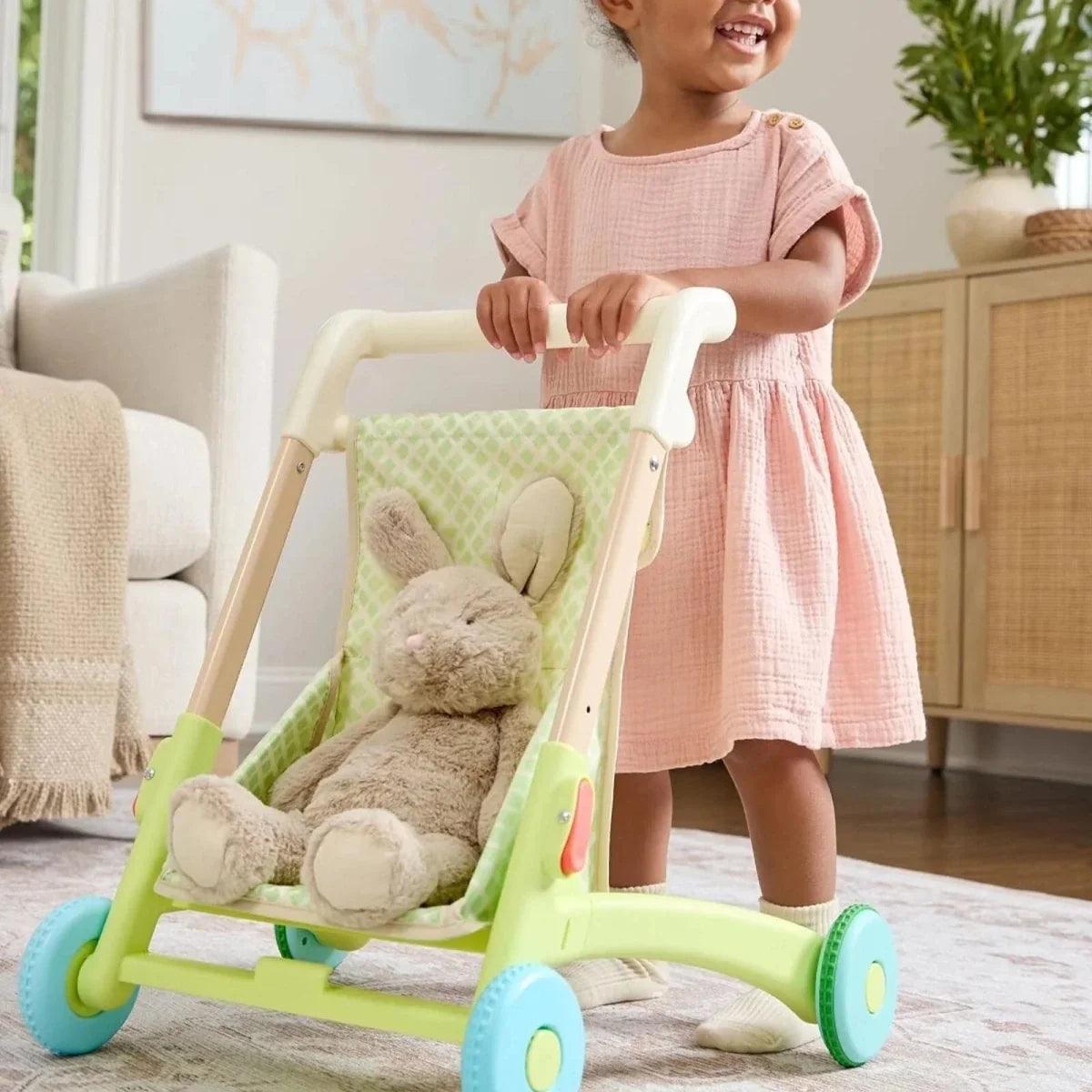 Green push walker with basket containing a stuffed animal