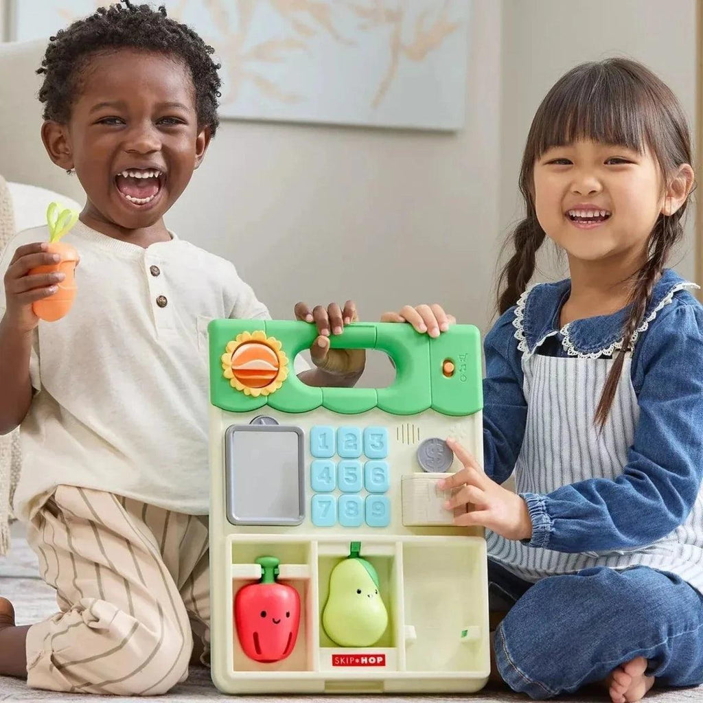 Two kids playing with green activity walker panel with buttons and toys