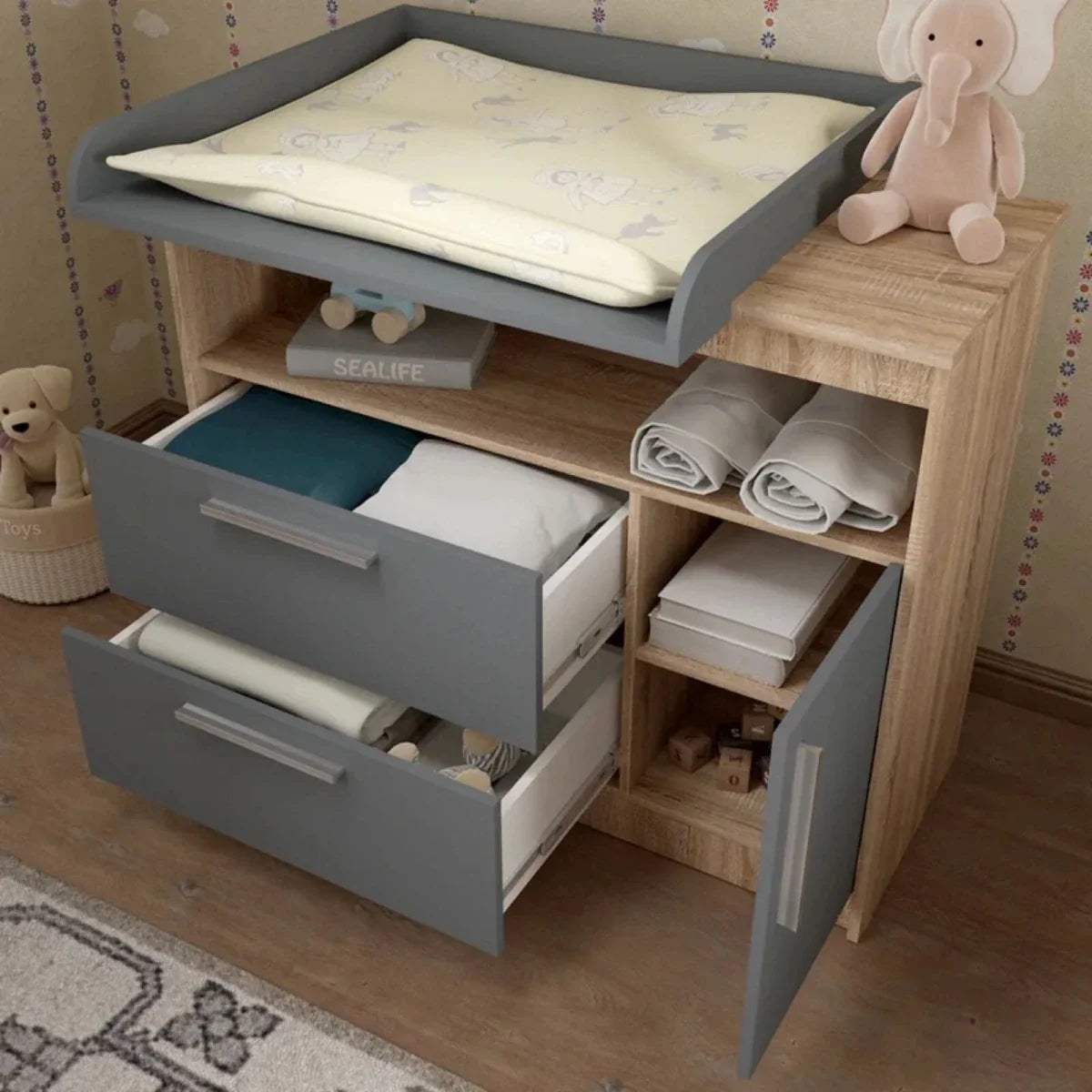 Kids changing unit with raised changing pad, open compartments, graphite drawers, oak frame.