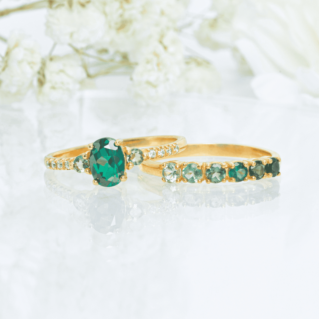 Gold-tone ring with oval green center stone and green tourmaline side stones