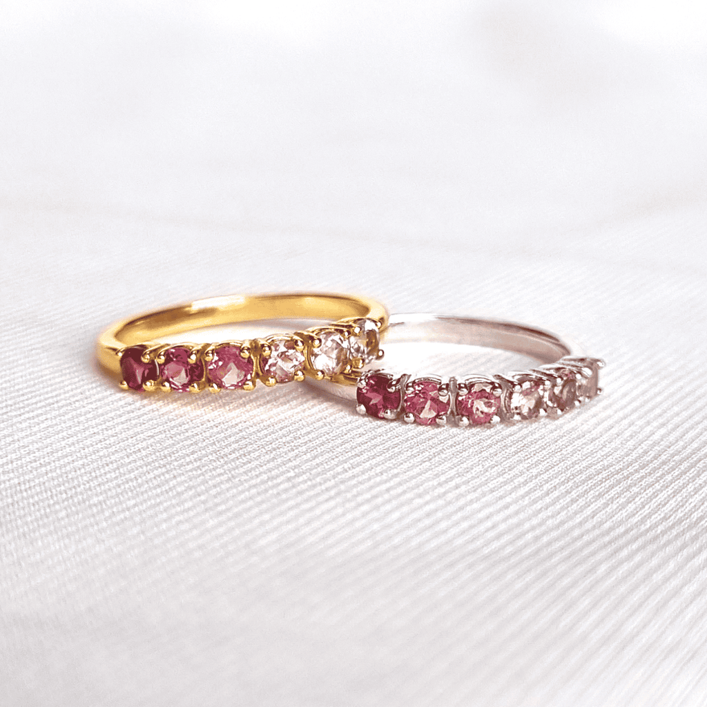Two eternity bands with pink and clear stones; one gold-toned, one silver-toned