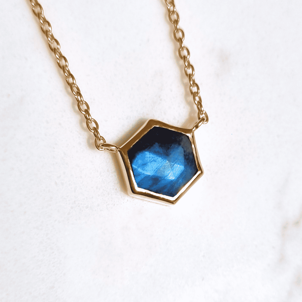 Close-up of gold vermeil labradorite necklace with faceted blue hex pendant