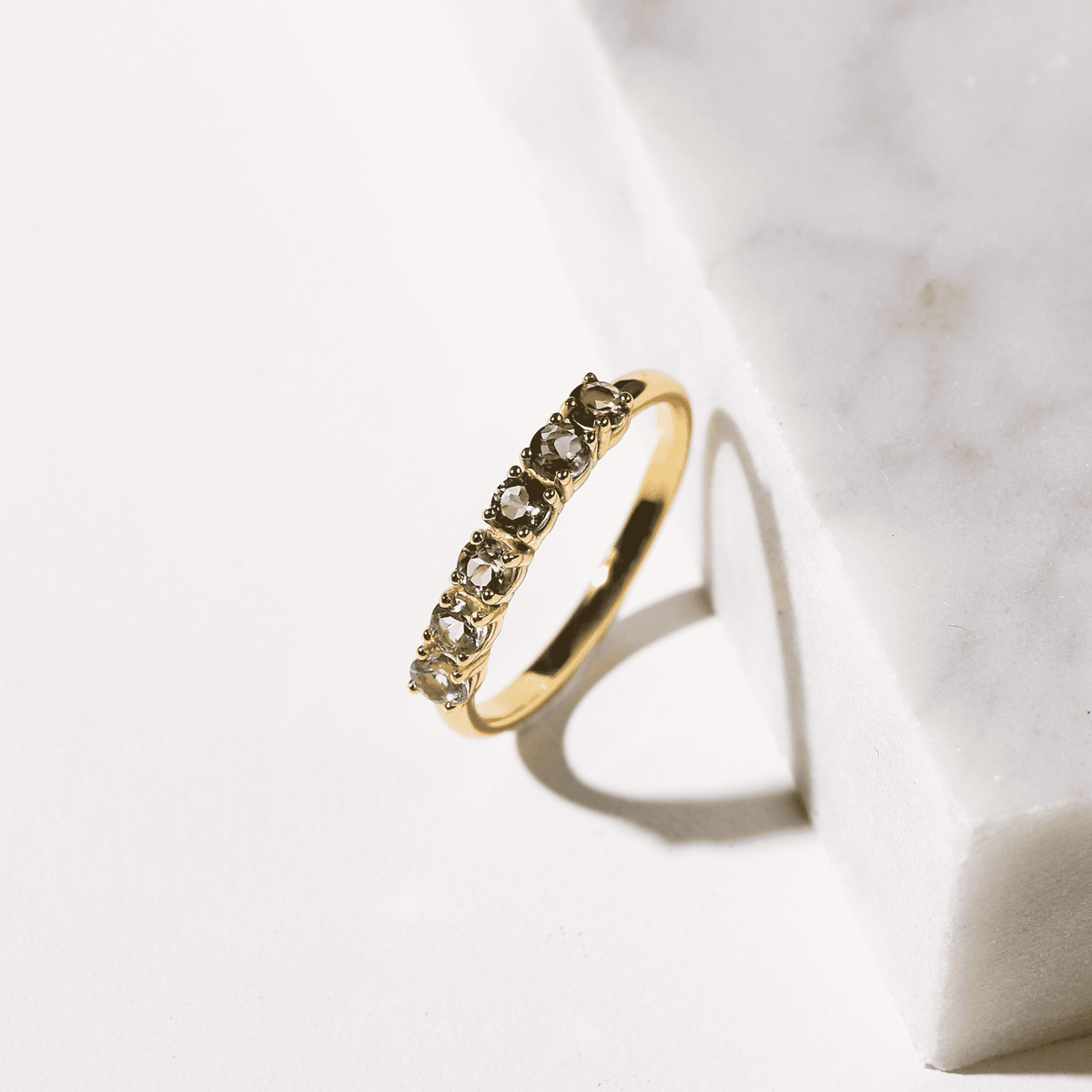 Gold-tone eternity band with small sparkling stones along the top edge