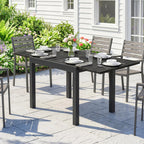 Black outdoor extending dining table with slatted top and matching chairs on patio