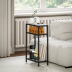 Black narrow side table with tempered glass top and three open shelves beside a sofa.