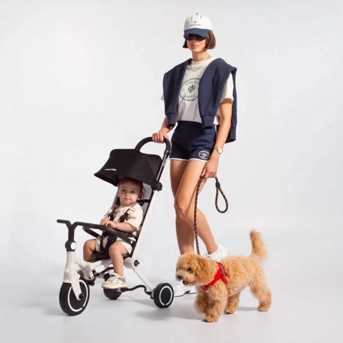 3-wheel stroller trike with canopy, white frame and dark seat, child seated
