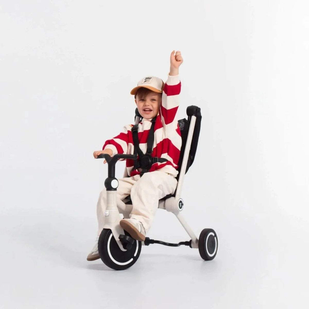 3-wheel stroller trike with black seat and safety bar, white frame, child seated