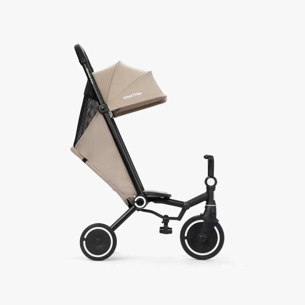 Stone and black three-wheel baby trike with extended canopy and padded seat, side view.