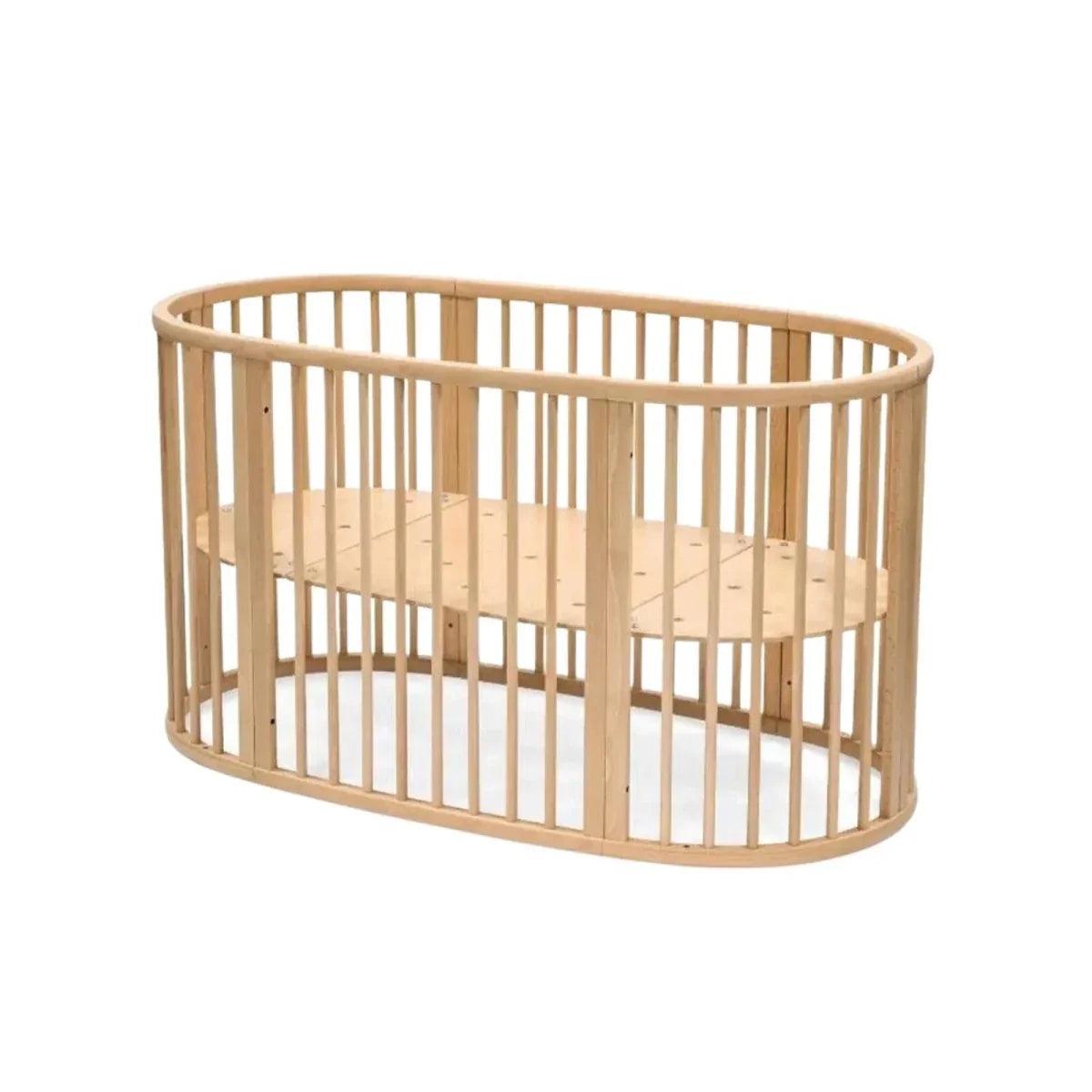 Natural wood oval baby crib with vertical slat rails and rounded end panels