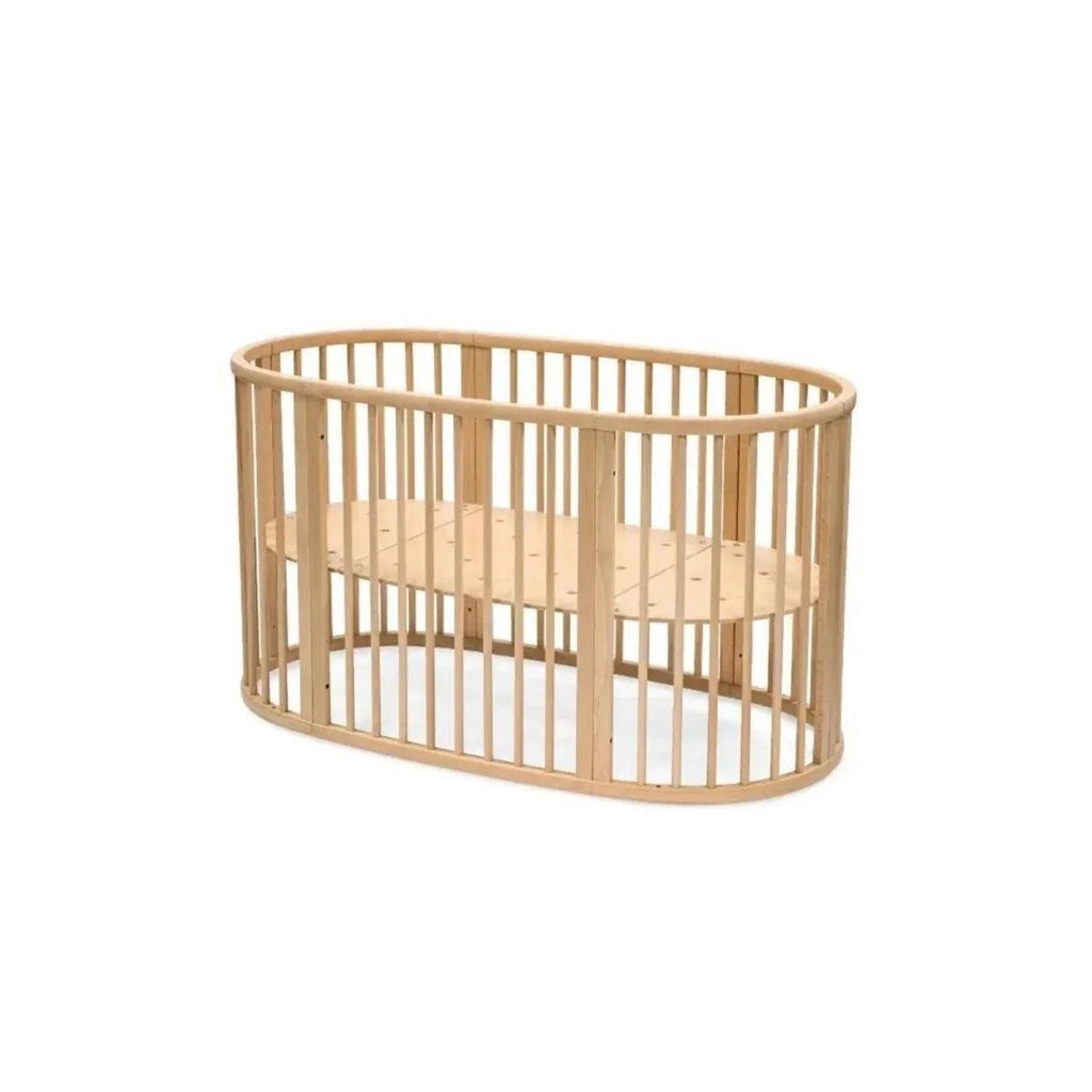 Natural wood oval baby crib with tall vertical slat sides and open mattress platform
