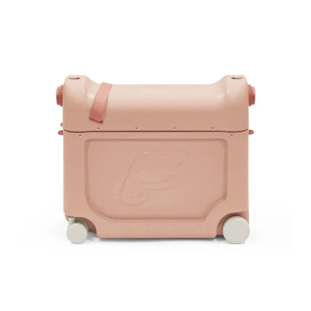 Coral pink BedBox ride-on suitcase front panel with recessed latch and rolling wheels