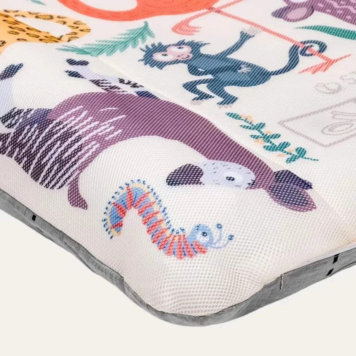 Corner view of animal print kids travel bed cover with padded gray edge