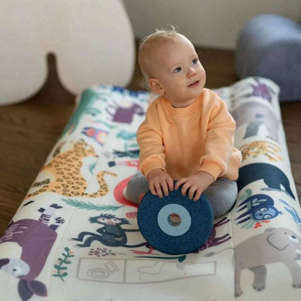 Baby playing on animal print kids travel bed with carry pouch nearby