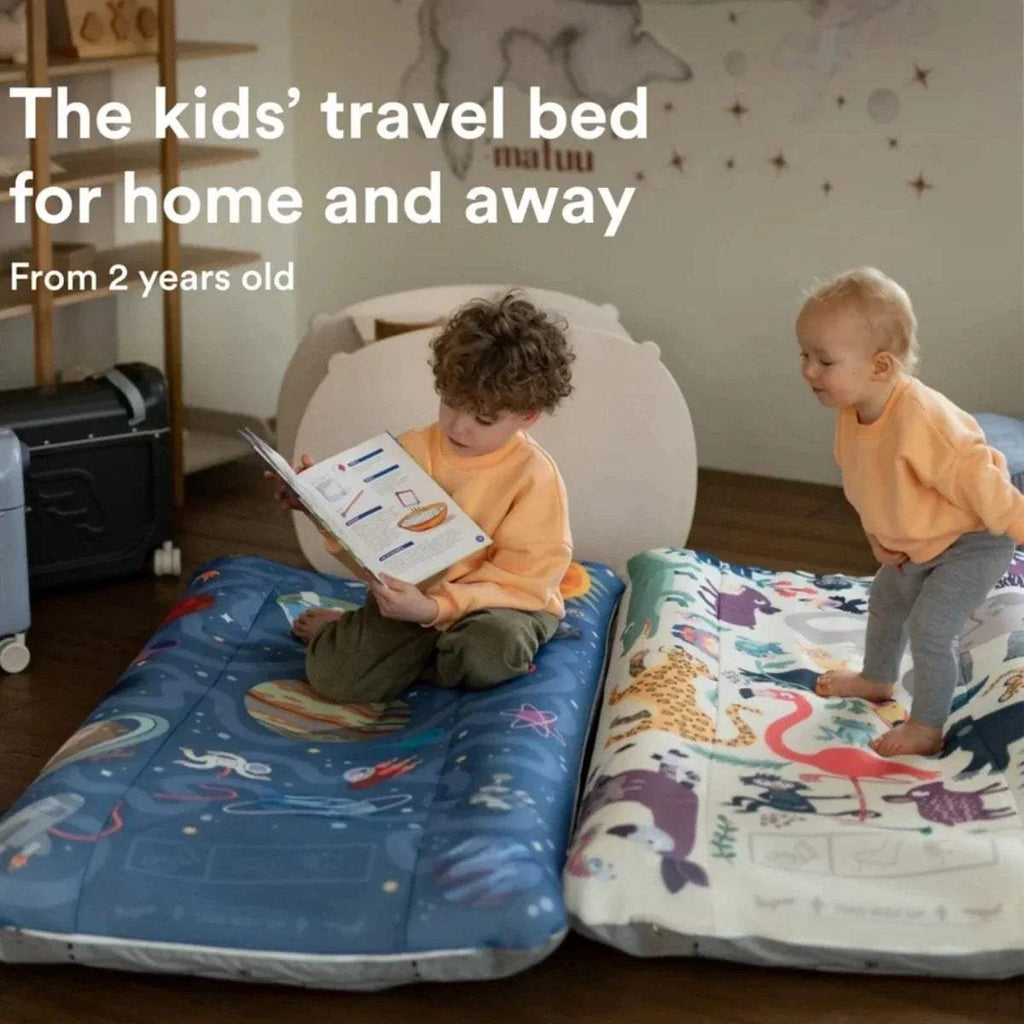 Kids using animal print travel beds, one seated and one standing