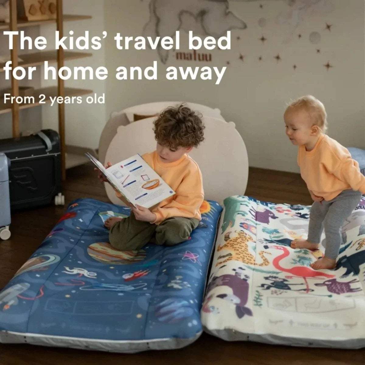 Kids using animal print travel beds, one seated and one standing